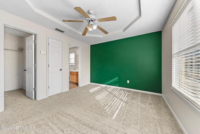 unfurnished bedroom with multiple windows, a closet, a textured ceiling, and carpet