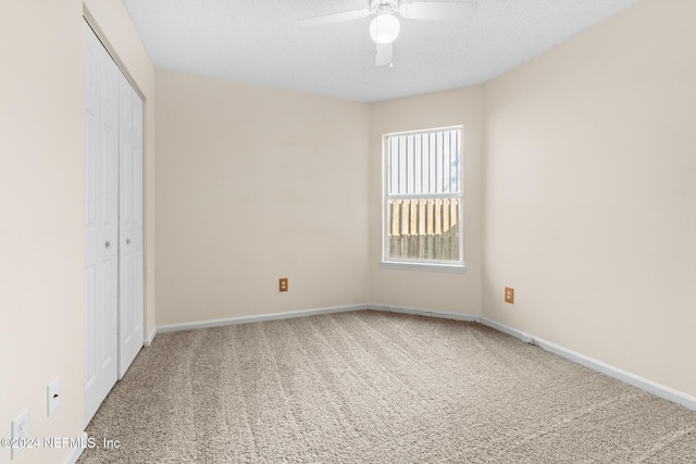 unfurnished bedroom with ceiling fan, carpet flooring, a closet, and a textured ceiling