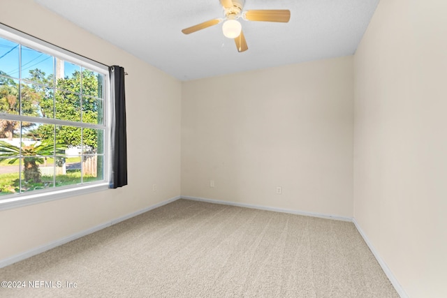 spare room featuring light carpet and ceiling fan