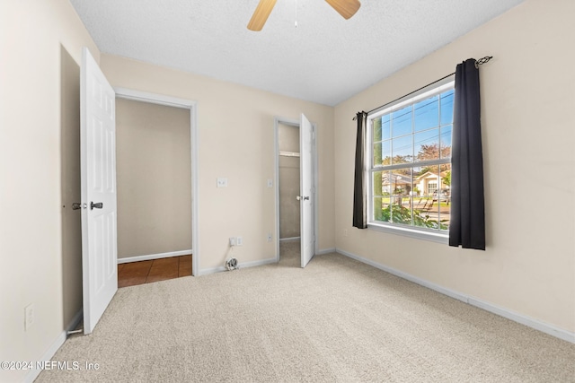 unfurnished bedroom featuring ceiling fan, a textured ceiling, and carpet flooring