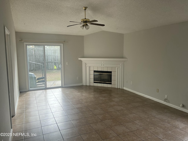 unfurnished living room with lofted ceiling, ceiling fan, tile patterned flooring, a textured ceiling, and a tiled fireplace