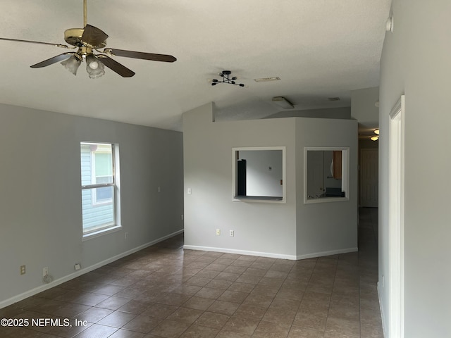 tiled spare room with vaulted ceiling and ceiling fan