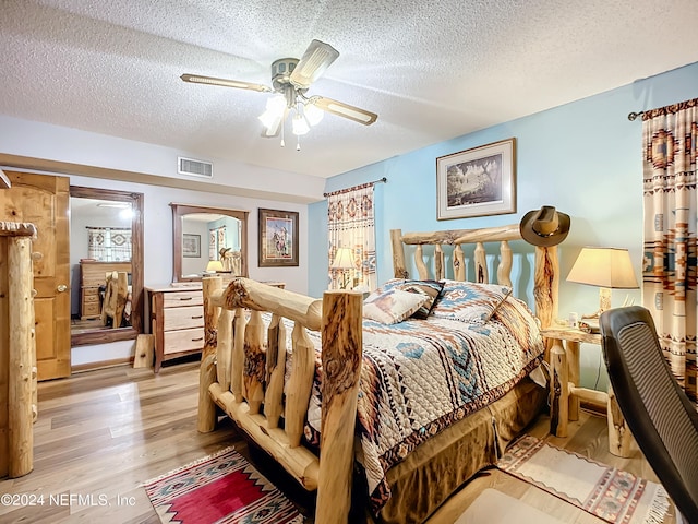 bedroom with ceiling fan, a textured ceiling, and light wood-type flooring