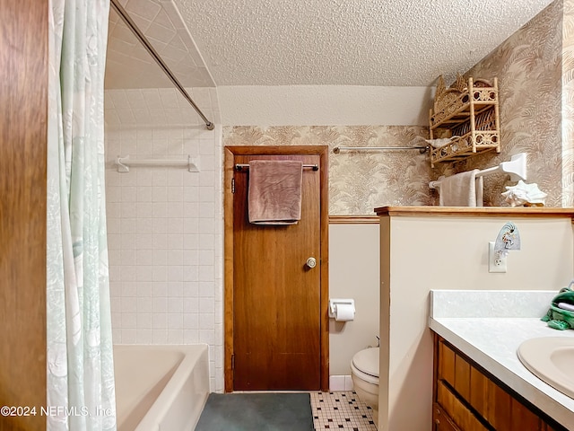 full bathroom with shower / tub combo with curtain, vanity, toilet, and a textured ceiling