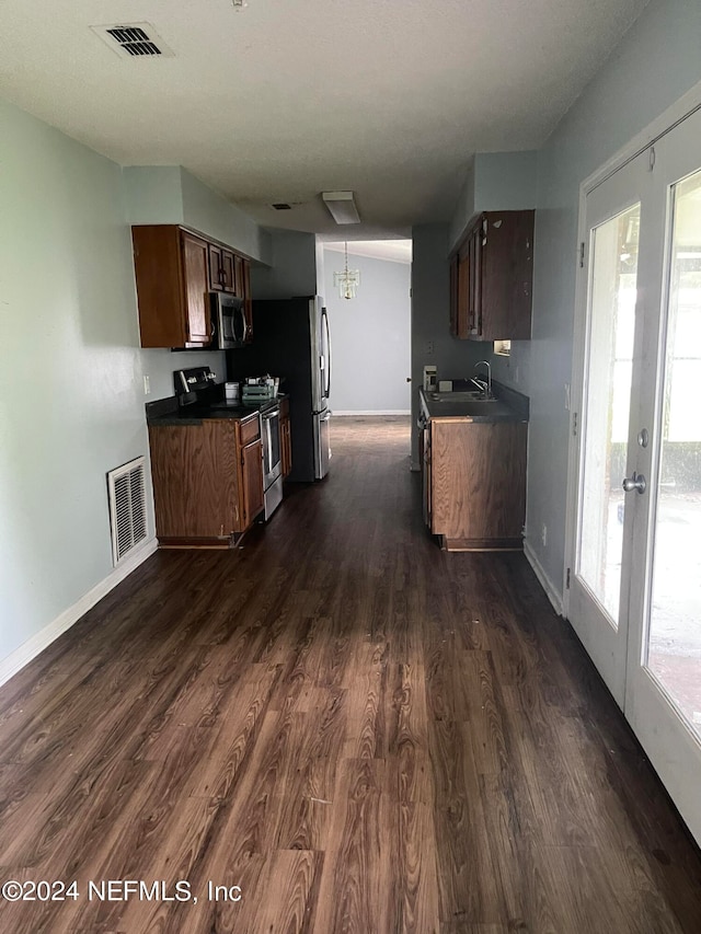 kitchen with stainless steel appliances, sink, a healthy amount of sunlight, and dark hardwood / wood-style flooring