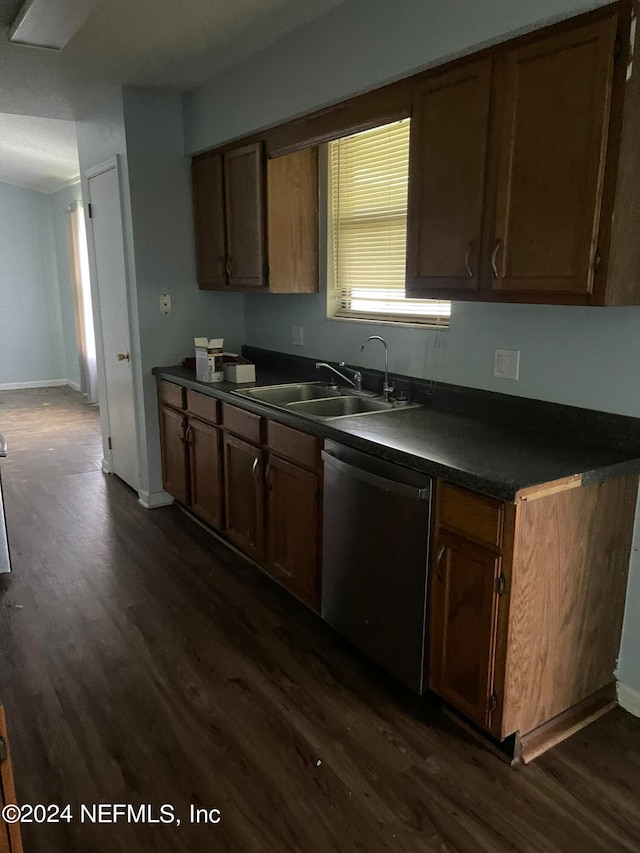 kitchen with dark wood-type flooring, sink, and stainless steel dishwasher