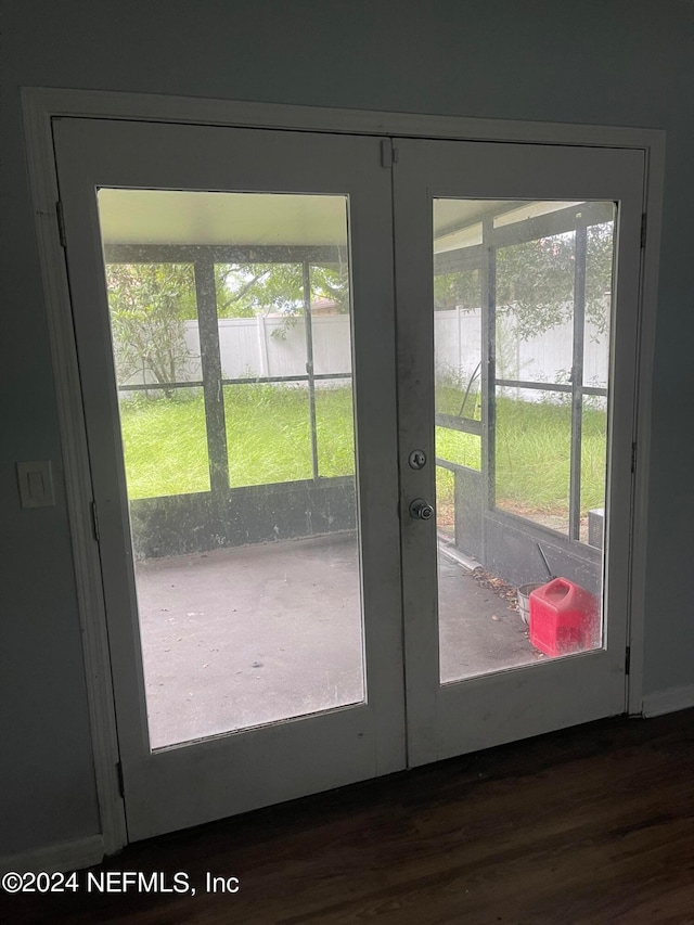 entryway featuring french doors, dark hardwood / wood-style floors, and a water view