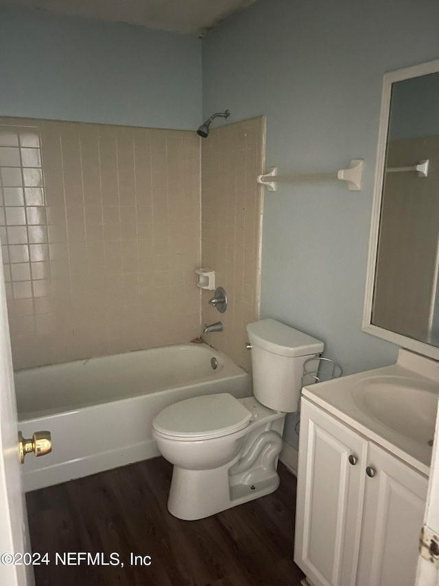 full bathroom with hardwood / wood-style floors, vanity, toilet, and tiled shower / bath