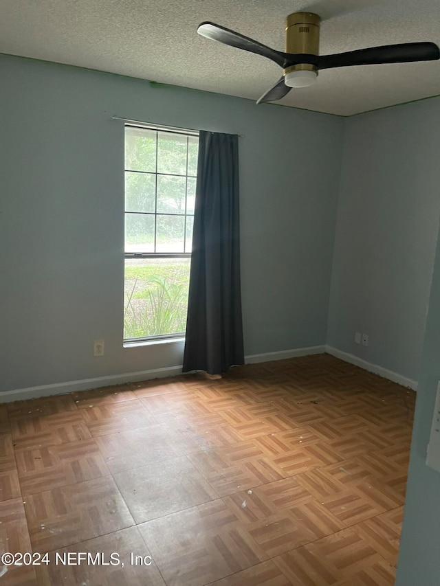 empty room with ceiling fan and light parquet flooring