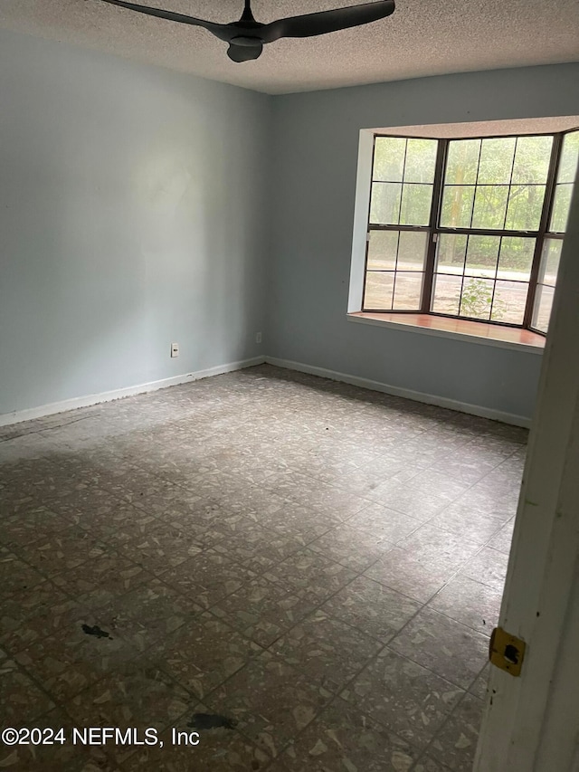 empty room with a textured ceiling and ceiling fan