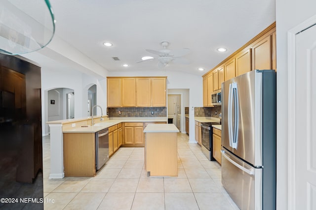 kitchen with kitchen peninsula, a kitchen island, stainless steel appliances, light brown cabinets, and ceiling fan