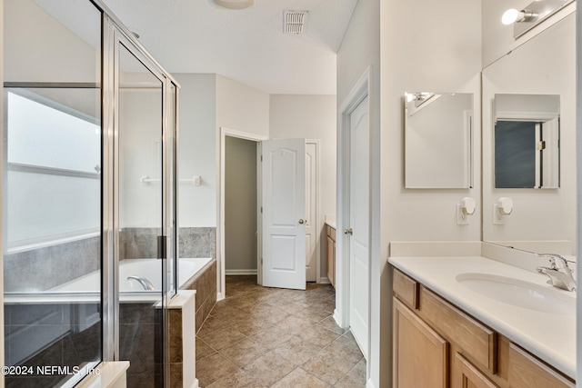 bathroom featuring plus walk in shower, tile patterned floors, and vanity