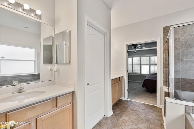 bathroom featuring tile patterned flooring, a textured ceiling, walk in shower, ceiling fan, and vanity