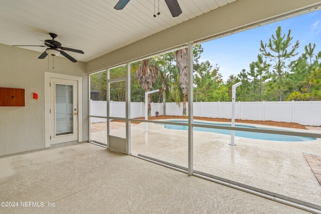 unfurnished sunroom featuring ceiling fan