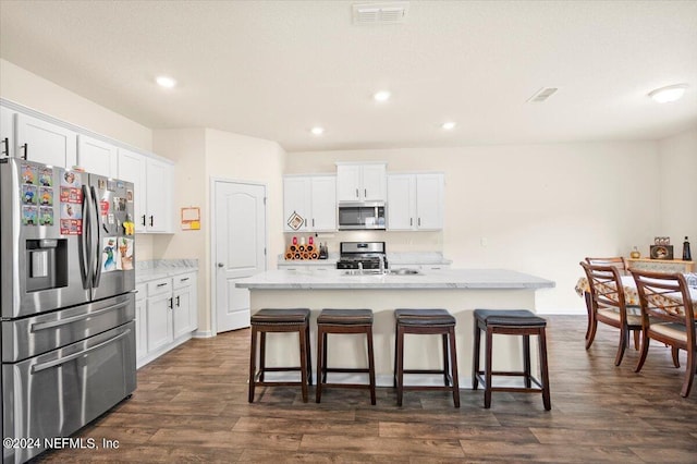 kitchen with a center island with sink, dark wood-type flooring, stainless steel appliances, and white cabinets