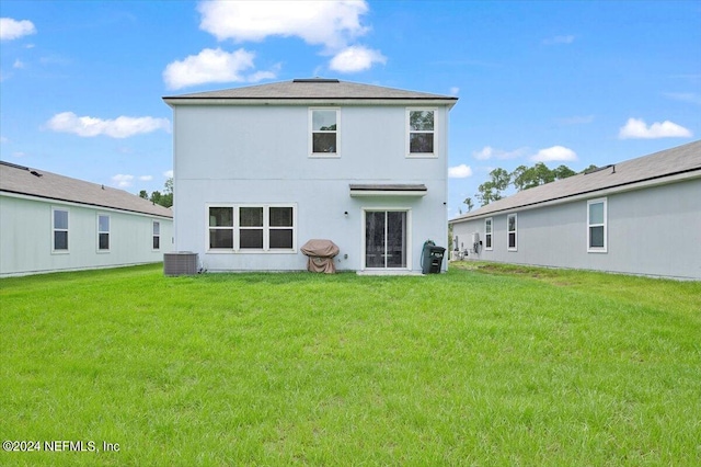 rear view of house with a lawn and central air condition unit