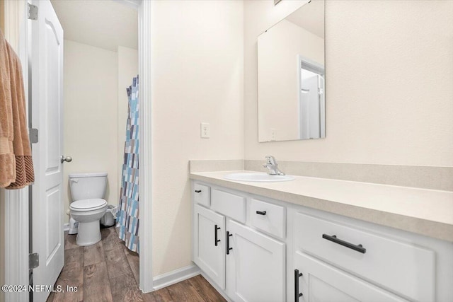 bathroom featuring wood-type flooring, vanity, and toilet