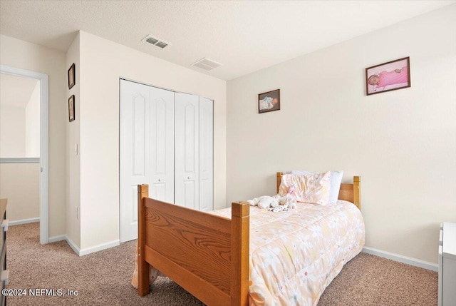 carpeted bedroom featuring a closet and a textured ceiling