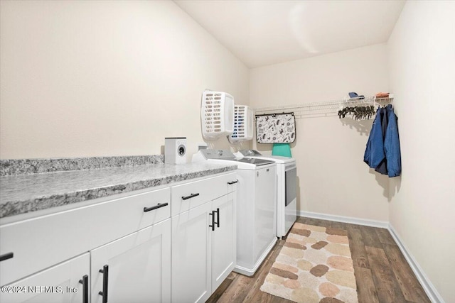 laundry room featuring cabinets, hardwood / wood-style flooring, and separate washer and dryer