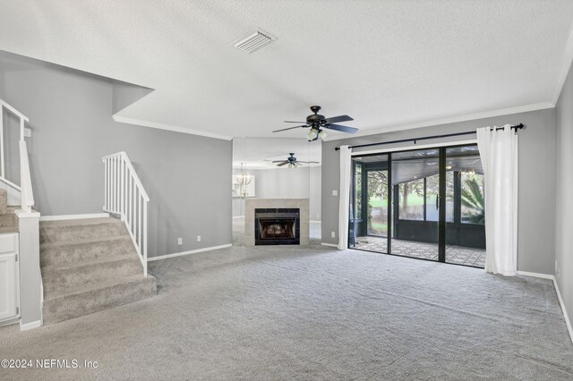 unfurnished living room featuring a textured ceiling, ceiling fan, a fireplace, and crown molding