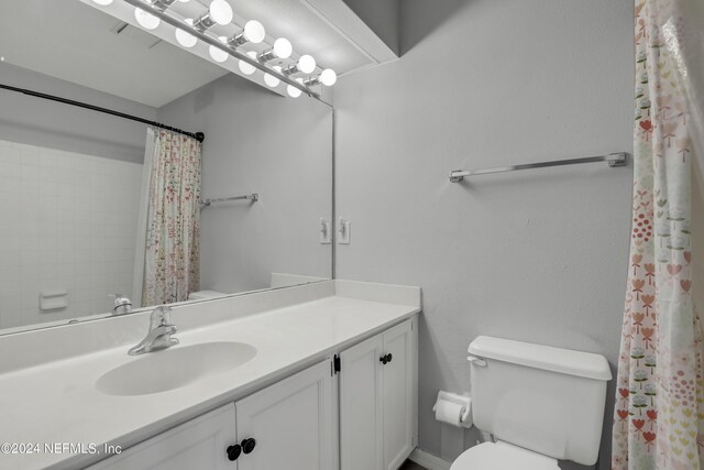 bathroom with curtained shower, vanity, and toilet