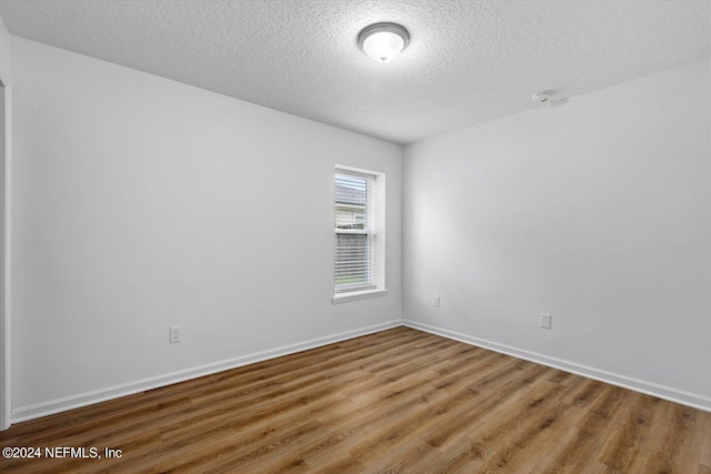 empty room featuring a textured ceiling and wood-type flooring