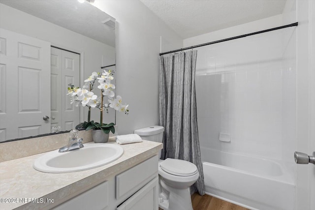 full bathroom featuring a textured ceiling, shower / bathtub combination with curtain, hardwood / wood-style floors, vanity, and toilet