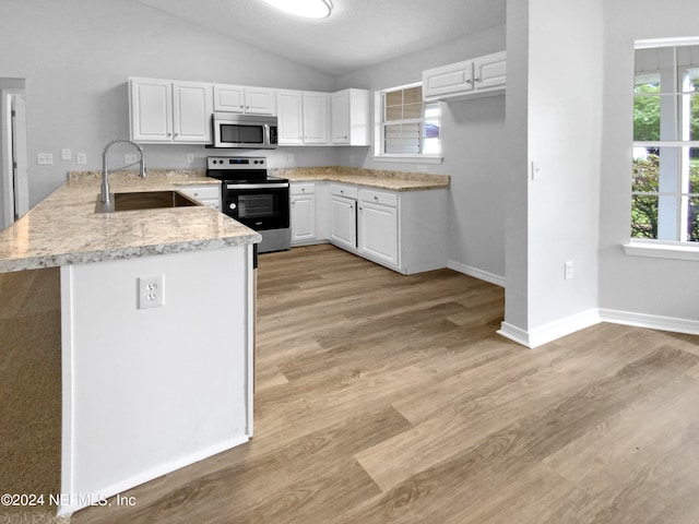 kitchen featuring stainless steel appliances, kitchen peninsula, sink, white cabinets, and light hardwood / wood-style floors