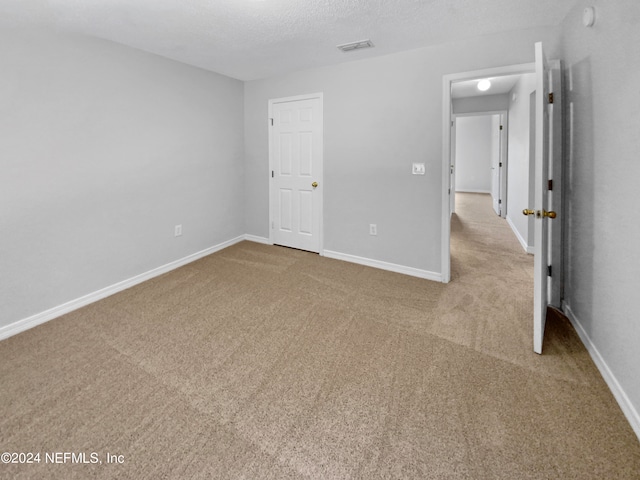 carpeted spare room with a textured ceiling