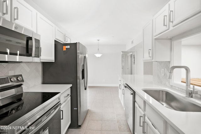 kitchen with stainless steel appliances, sink, light tile patterned floors, and white cabinets