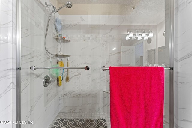 bathroom featuring a textured ceiling and an enclosed shower