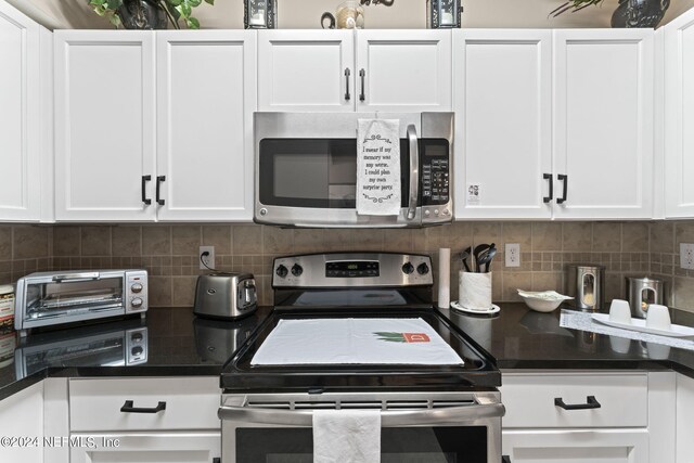 kitchen with white cabinets, backsplash, and appliances with stainless steel finishes