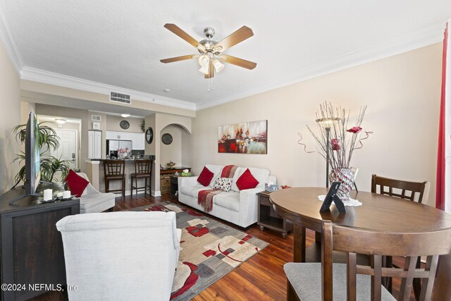 living room featuring ceiling fan, a textured ceiling, crown molding, and dark hardwood / wood-style flooring