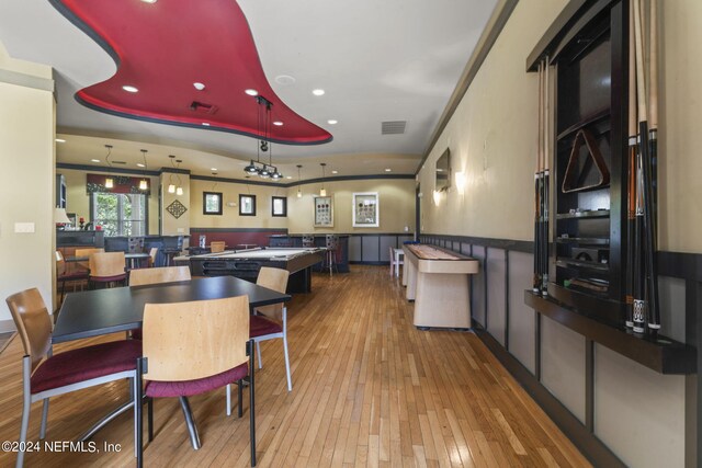 dining room with light hardwood / wood-style flooring and a raised ceiling