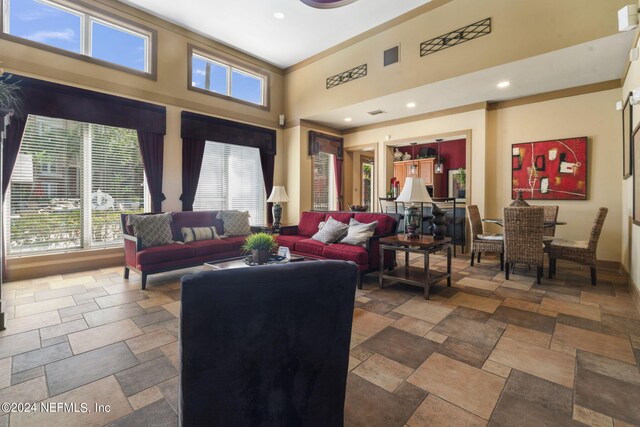 living room with ornamental molding and a high ceiling