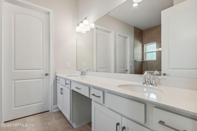 bathroom with vanity, tiled shower, and tile patterned floors