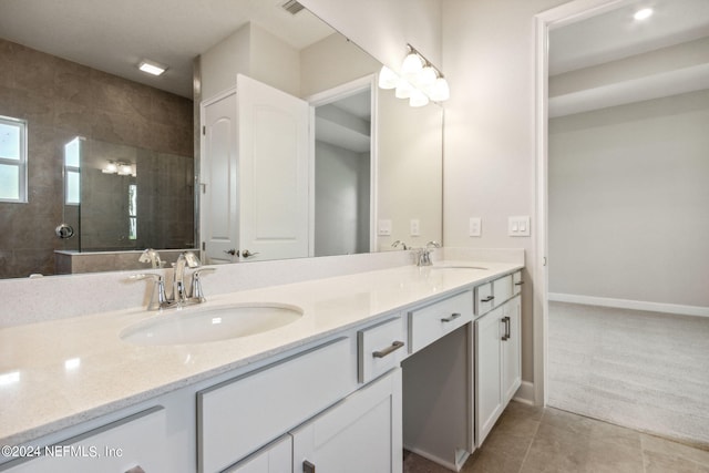 bathroom featuring vanity, tile patterned flooring, and a tile shower