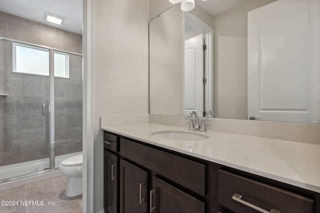 bathroom featuring walk in shower, tile patterned flooring, vanity, and toilet