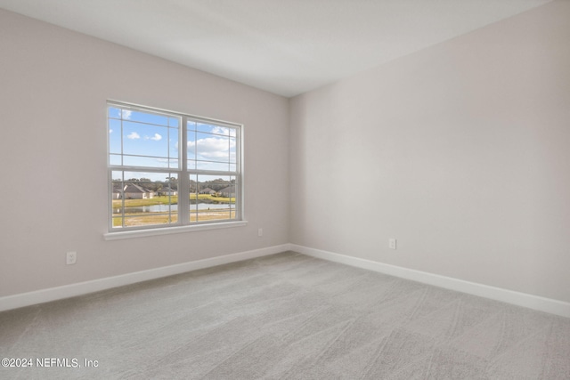 carpeted spare room featuring a water view