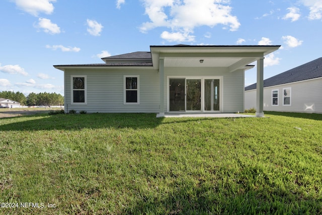 back of house with a lawn