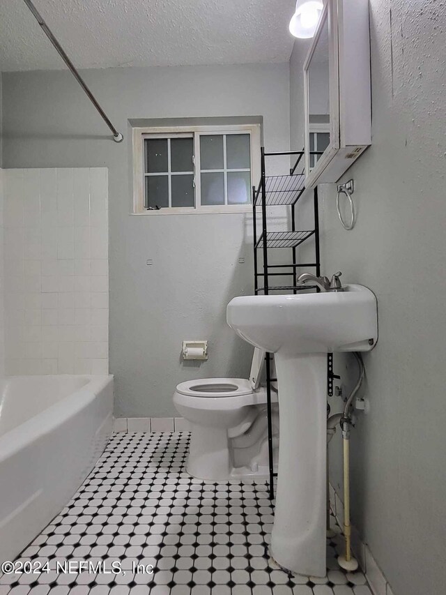 bathroom with bathing tub / shower combination and toilet