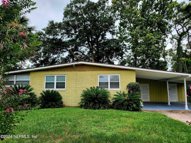 view of front of house with a front yard and a carport