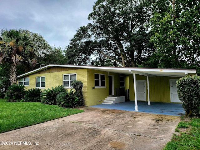 view of front of house with a front yard and a carport