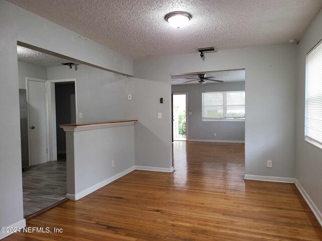 spare room with ceiling fan, hardwood / wood-style flooring, plenty of natural light, and a textured ceiling