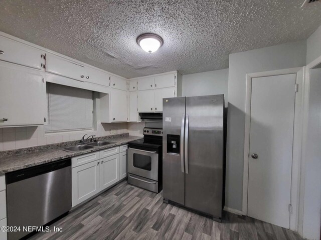 kitchen featuring white cabinets, sink, a textured ceiling, stainless steel appliances, and dark hardwood / wood-style floors