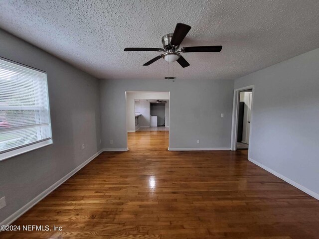 unfurnished room featuring ceiling fan, a textured ceiling, and dark hardwood / wood-style flooring