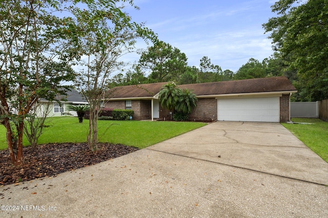 ranch-style home featuring a garage and a front lawn