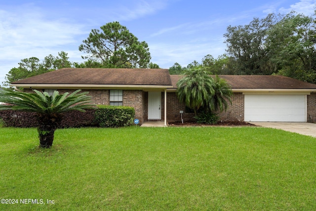 ranch-style house featuring a garage and a front lawn