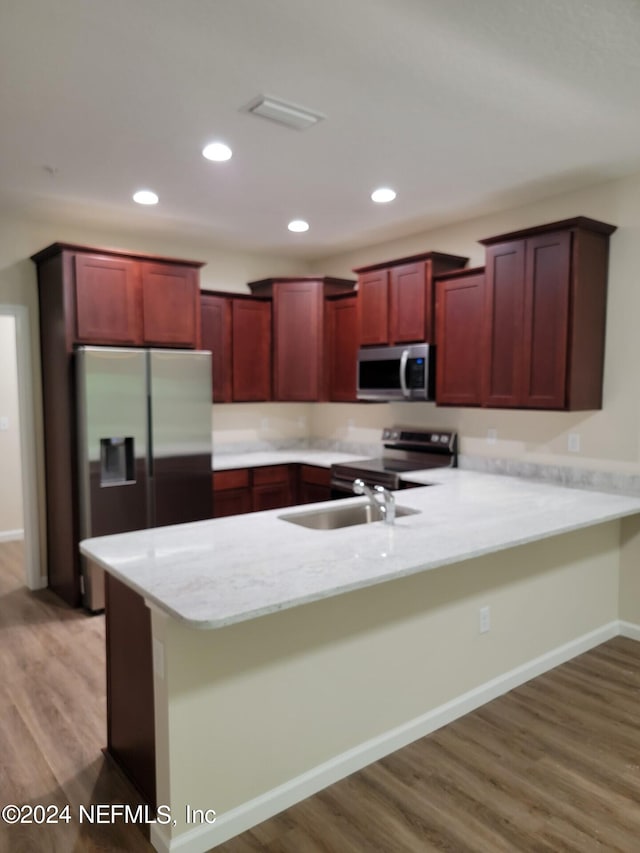 4148 Quiet Creek Loop Unit 132, Middleburg, FL 32068 - kitchen featuring a peninsula, light wood-style flooring, a sink, dark brown cabinets, and appliances with stainless steel finishes
