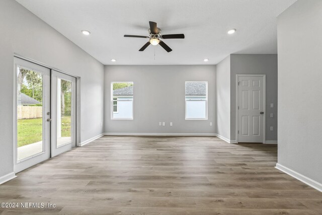 spare room with light wood-type flooring, ceiling fan, and a wealth of natural light